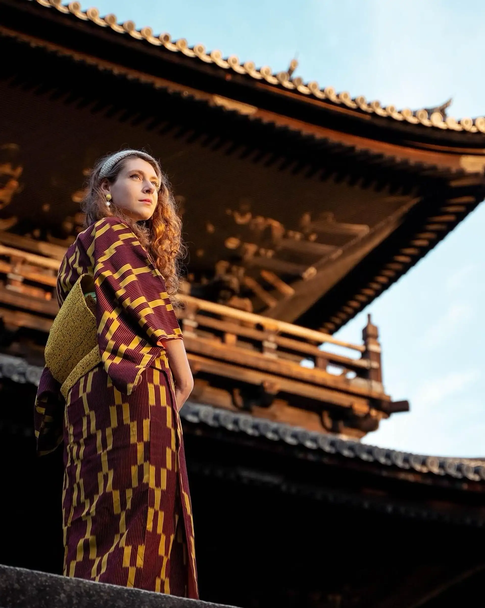 Travel in Asia - A young woman wearing a Japanese yukata standing in front of temple in Kyoto