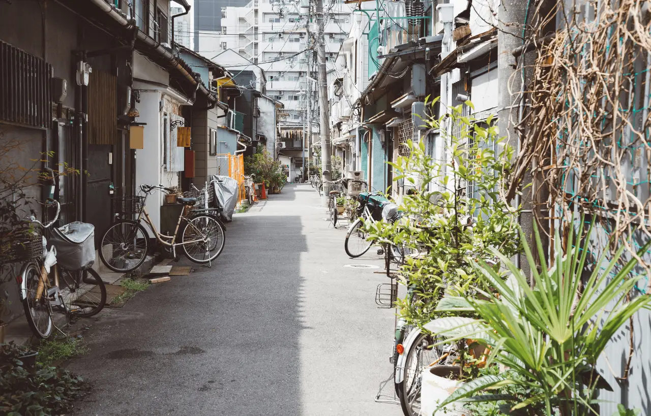 Fahrräder stehen in einer engen, ruhigen Gasse mit traditionellen Häusern im Nakazakicho Viertel in Osaka