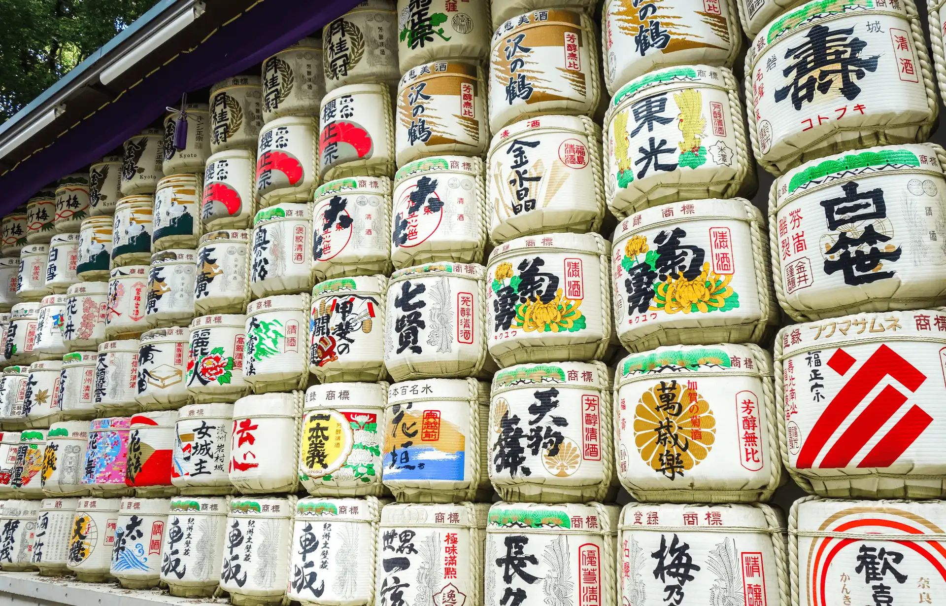 alignement de barils de sake traditionnels en paille decores de kanjis au sanctuaire meiji jingu a tokyo