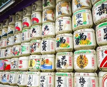 Splendeur de l'automne au jardin Shinjuku Gyoen à Tokyo avec les érables rouges (Momiji) et la tour NTT Docomo en arrière-plan, une expérience de voyage zen recommandée par Shanti Travel.
