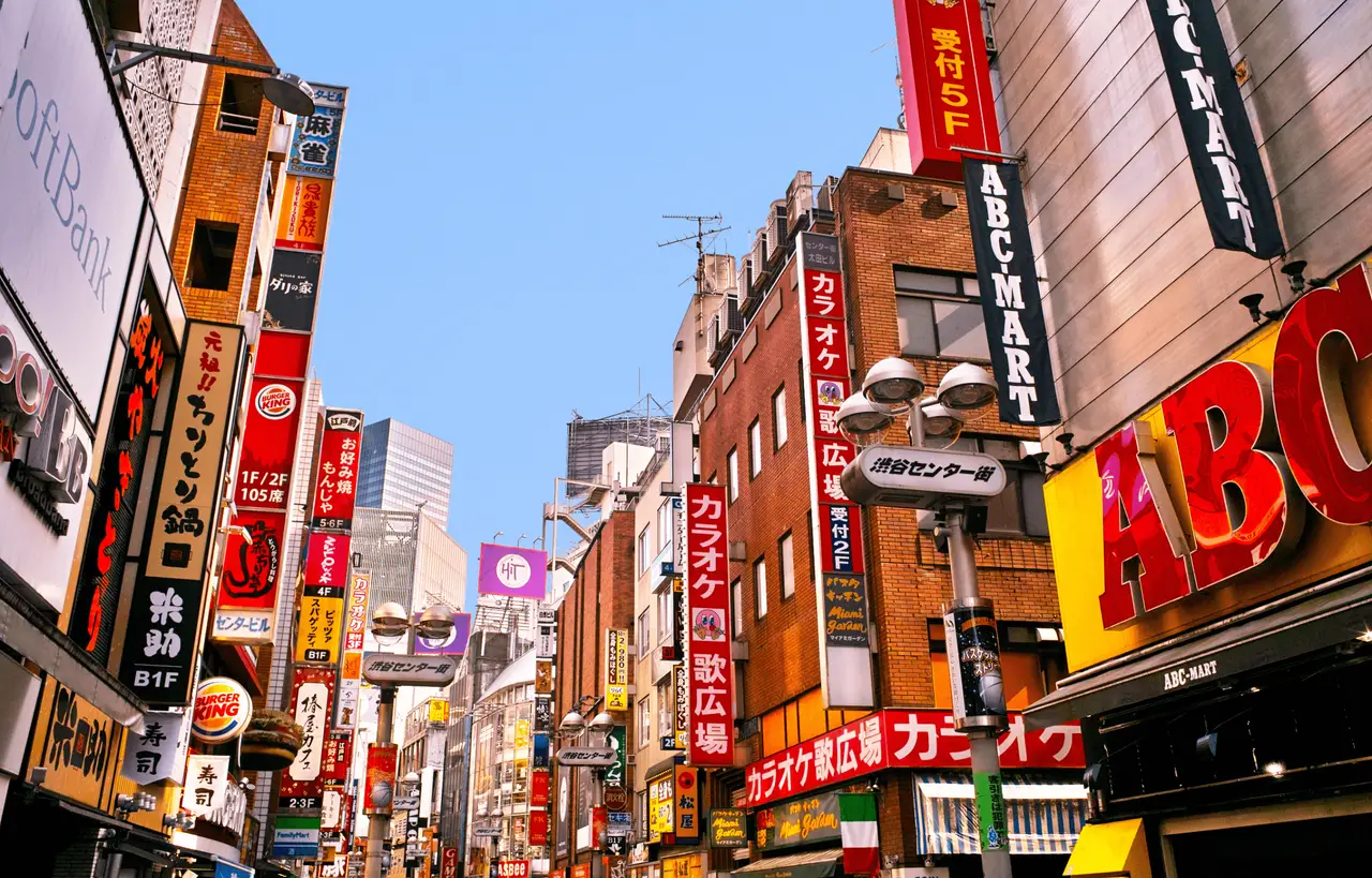 Lebhafte Straße mit bunten Werbeschildern und Gebäuden in Shibuya Tokio Japan