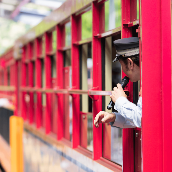 Contrôleur japonais annonçant les paysages de la rivière Hozugawa à bord du Sagano Romantic Train à Arashiyama, une immersion nostalgique et panoramique incluse dans le circuit ferroviaire de Shanti Travel.
