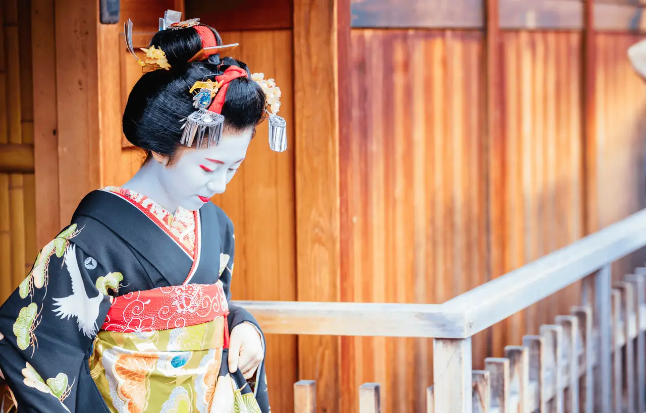 Junge Geisha oder Maiko in traditionellem Kimono in einer Holzgasse in Kyoto Japan