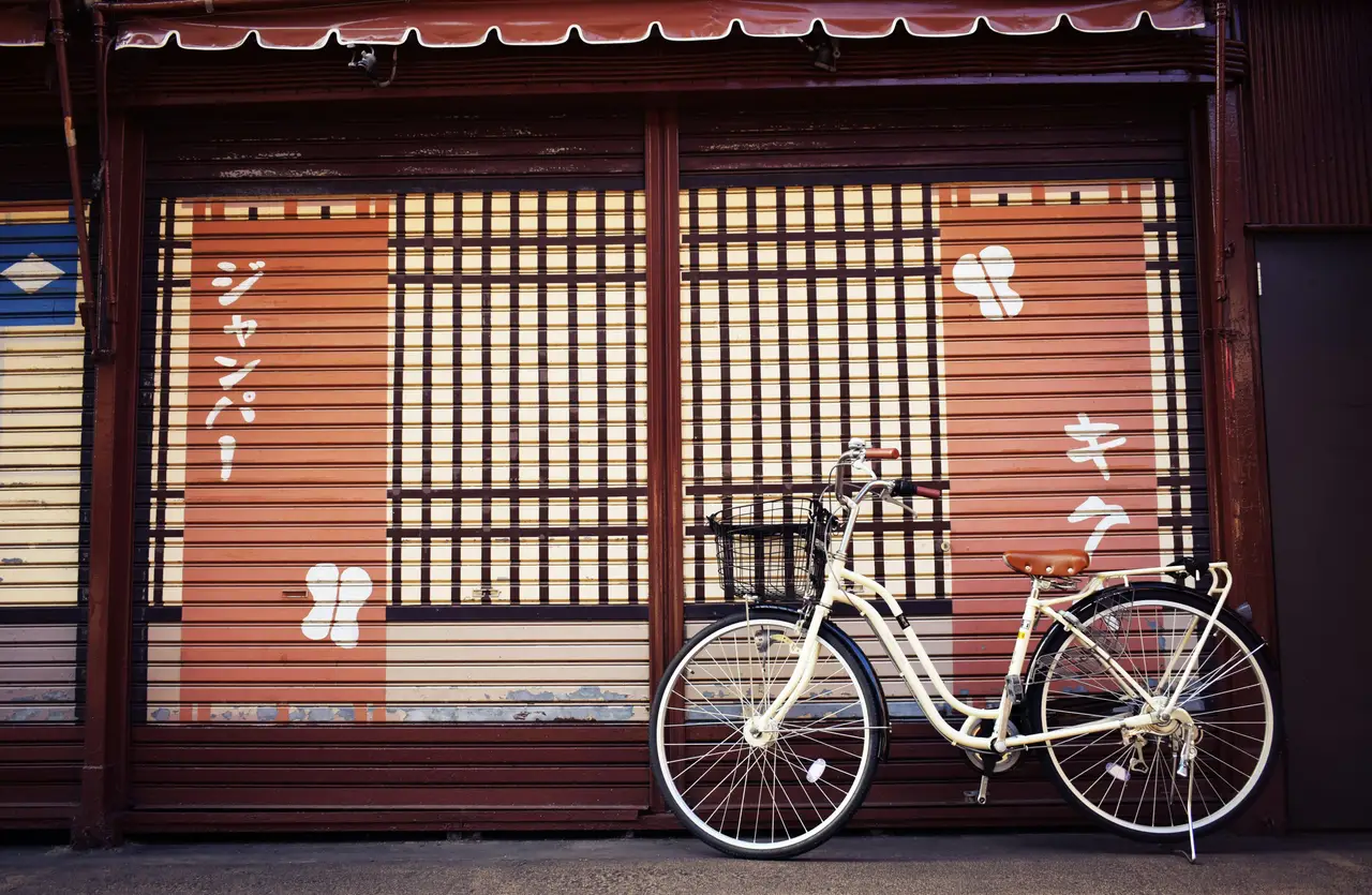 Ein Fahrrad steht vor einem traditionellen geschlossenen japanischen Laden in einer Straße in Tokio