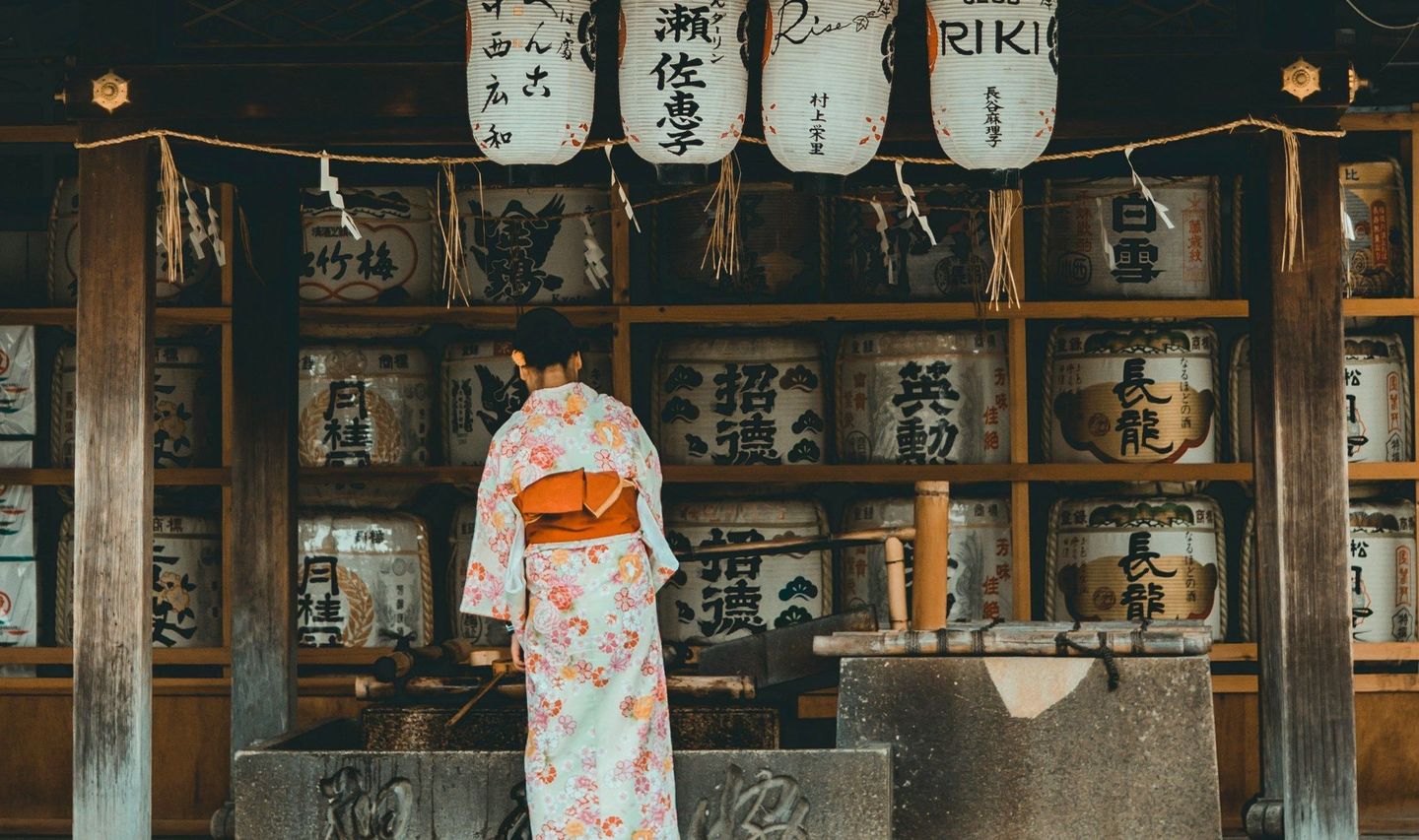 Travel in Asia - A woman in a traditional kimono in front of a Shinto shrine in Japan