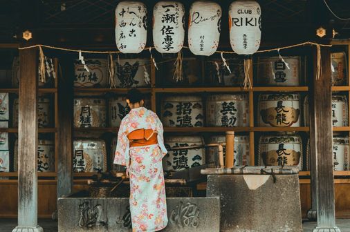 Travel in Asia - A woman in a traditional kimono in front of a Shinto shrine in Japan
