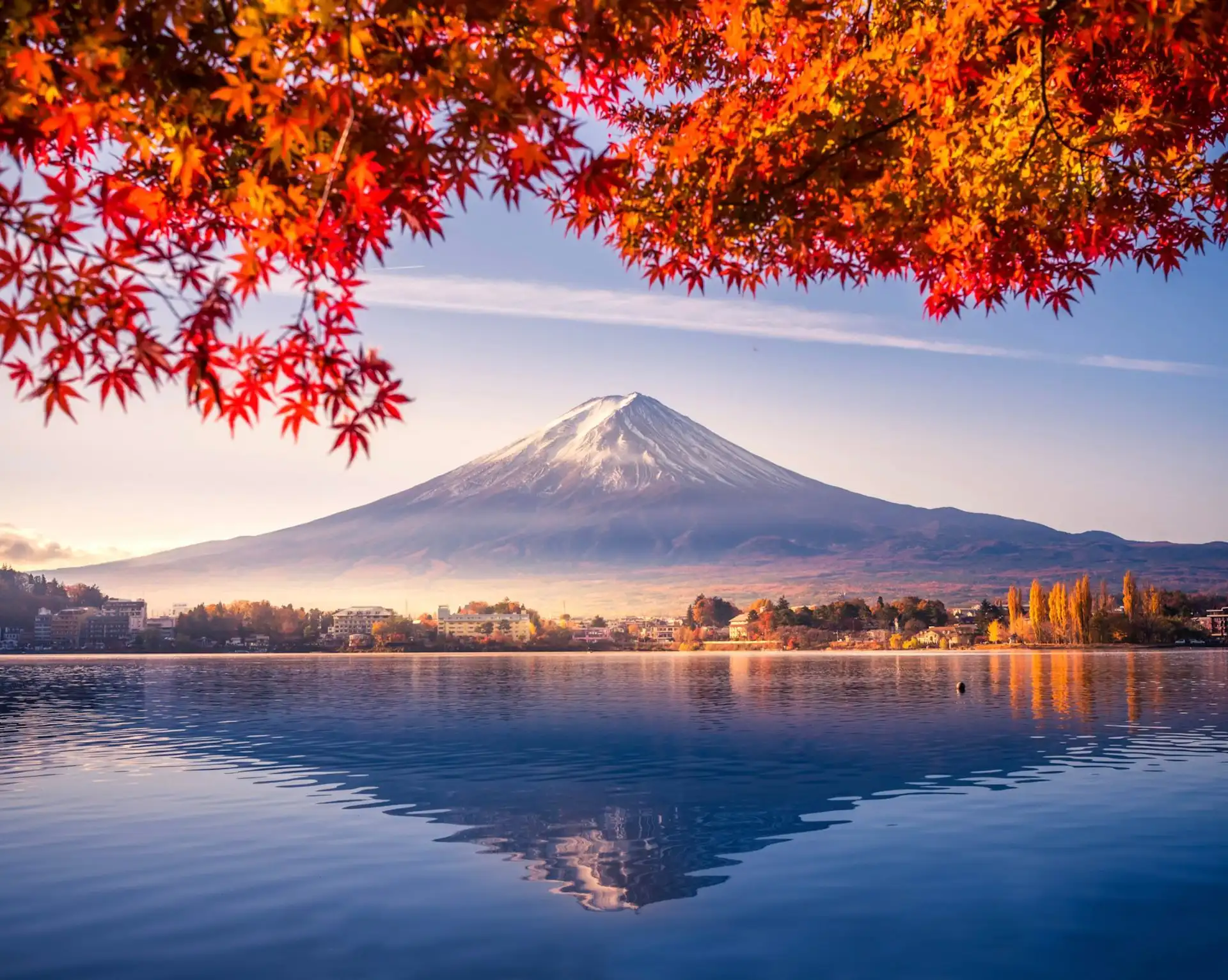 Vue spectaculaire du Mont Fuji enneigé se reflétant dans le lac Kawaguchiko encadré par des érables rouges d'automne au Japon.