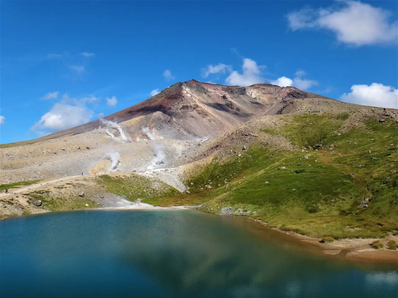 Parc Daisetsuzan - Paysage volcanique et lac de montagne sous un ciel bleu, le "toit de Hokkaido" au Japon.