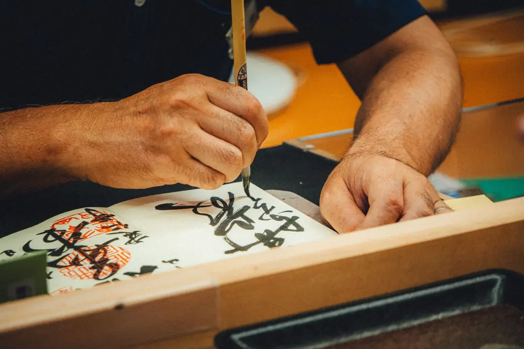 Prêtre qui calligraphie dans un goshuincho