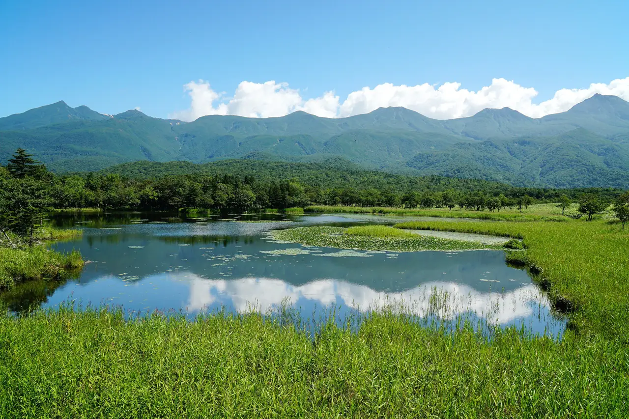 Parc Shiretoko - Le lac Ichiko reflétant les montagnes sous un ciel bleu, site sauvage classé à l'UNESCO à Hokkaido.