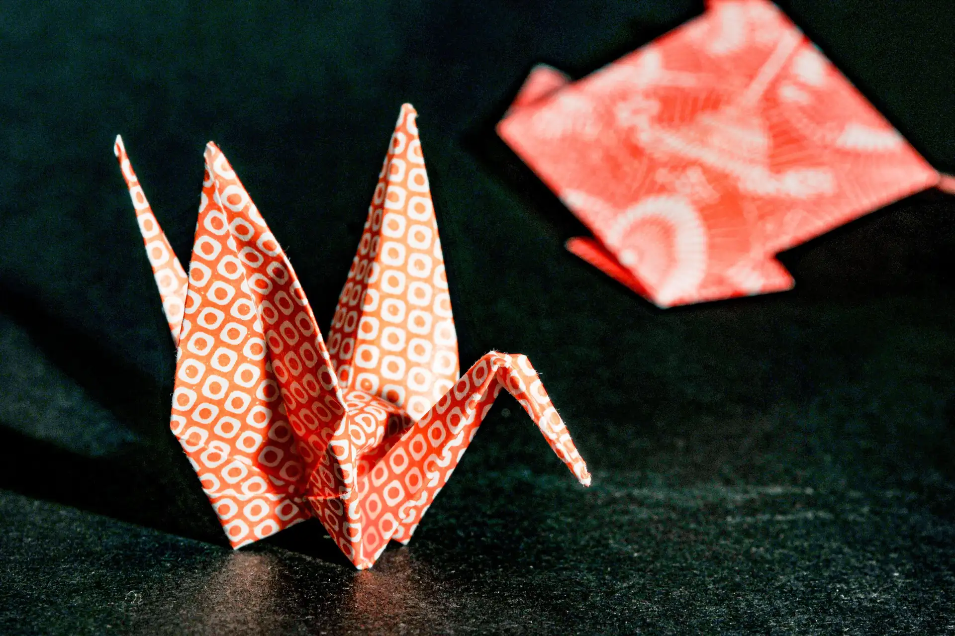 Conceptions artistiques japonaises – Grue en origami pliée dans un papier traditionnel motif rouge et blanc.