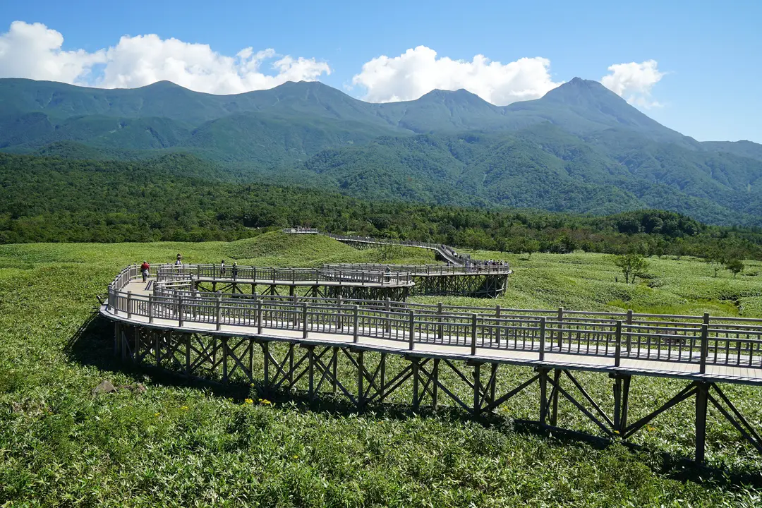 Hokkaido sauvage — Promenade sur les pontons en bois à travers les 5 lacs de Shiretoko face aux montagnes du Japon.