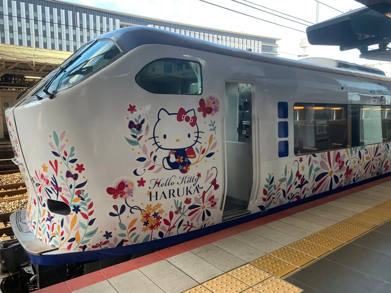Design extérieur coloré du train Hello Kitty Haruka de la JR West, une expérience de transport unique et ludique pour rejoindre l'aéroport à la fin d'un circuit Shanti Travel au Japon.