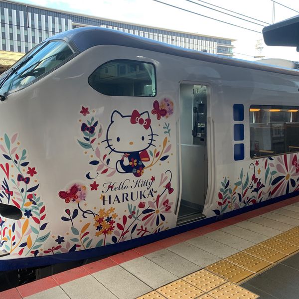 Design extérieur coloré du train Hello Kitty Haruka de la JR West, une expérience de transport unique et ludique pour rejoindre l'aéroport à la fin d'un circuit Shanti Travel au Japon.