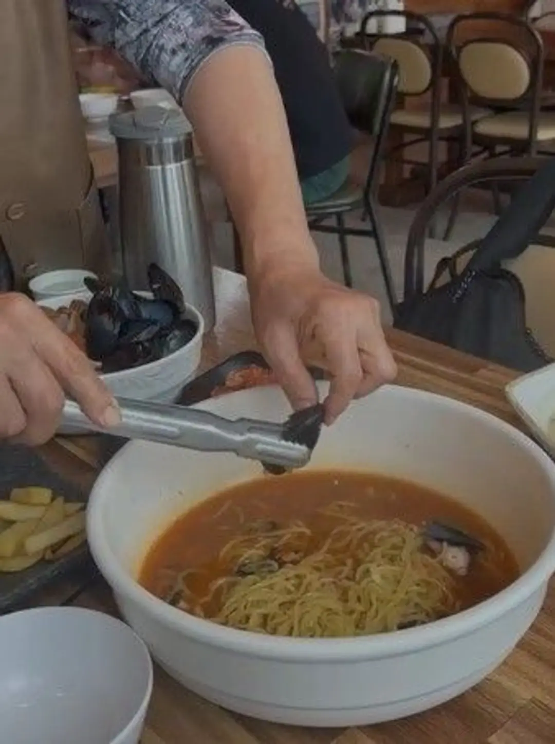 Préparation d'un grand bol de soupe de nouilles ramen aux fruits de mer frais dans un restaurant traditionnel de l'île de Jeju.