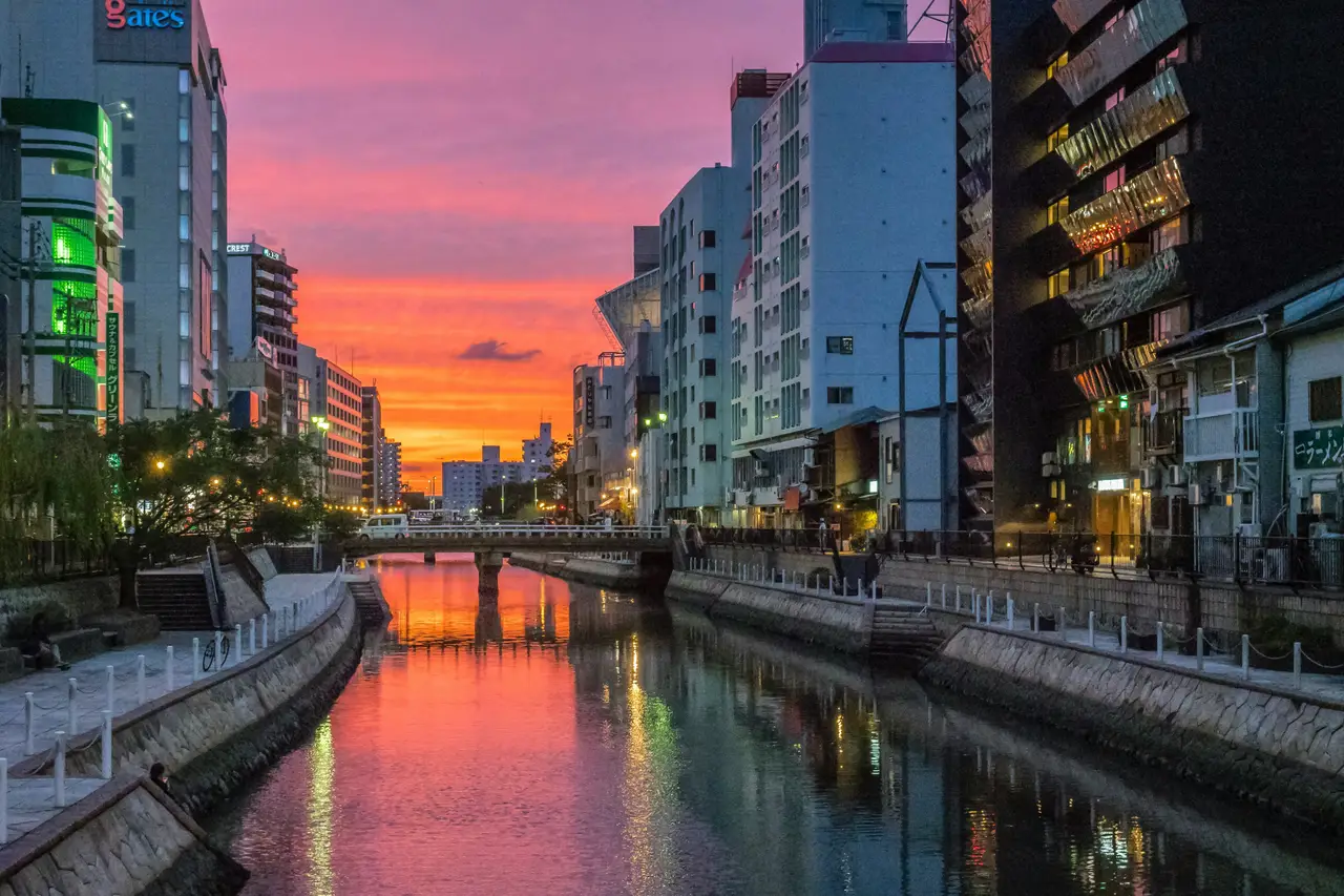 scenic city view of fukuoka canal and modern buildings along the river at sunset under a colorful sky kyushu