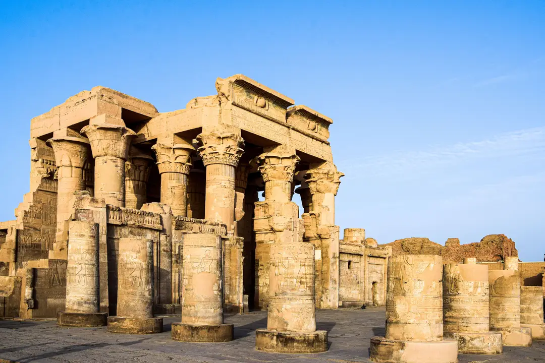 Ruines et colonnes gravées du temple de Kom Ombo sous un ciel bleu en Égypte.