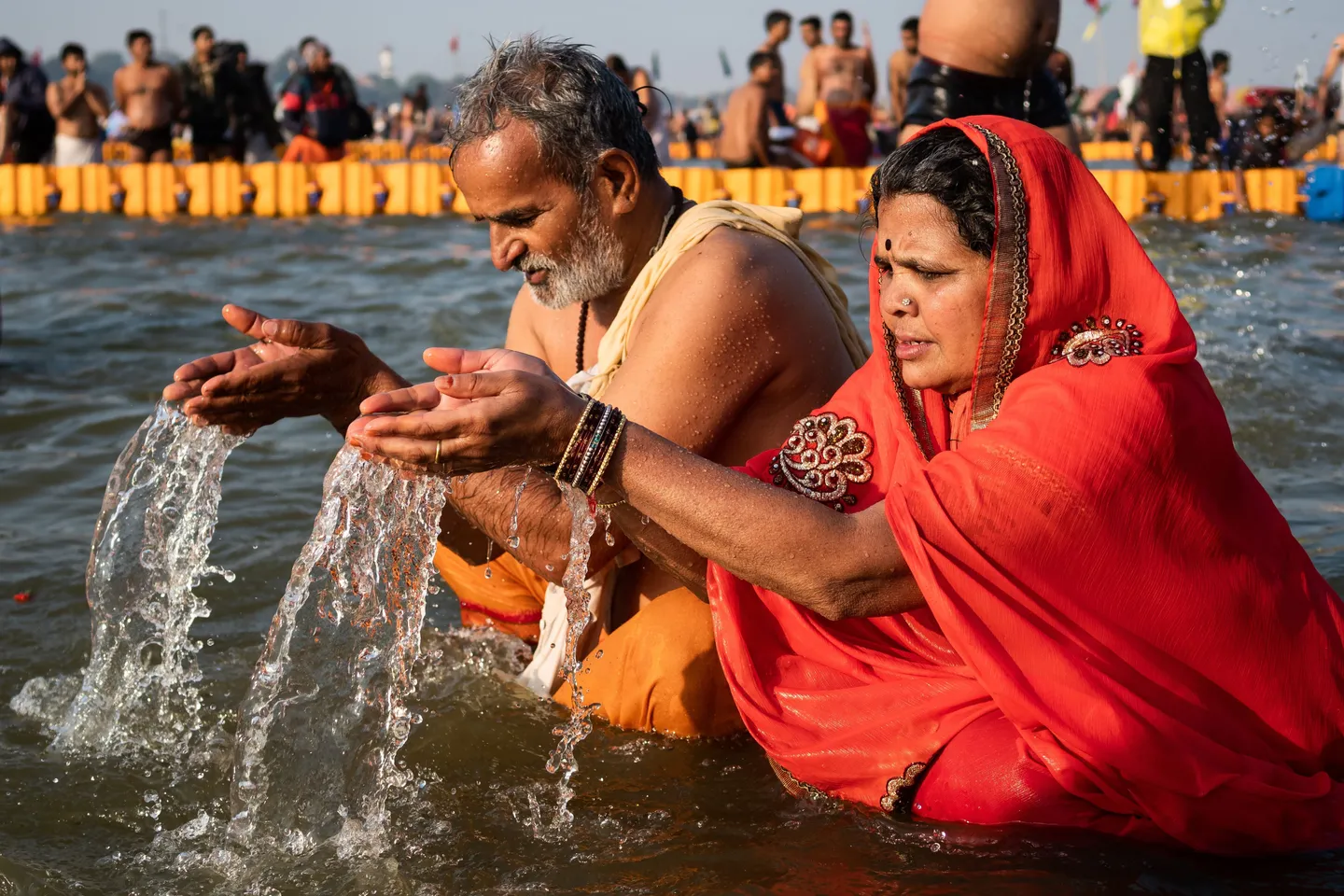 voyage en Inde - Pèlerins hindous pratiquant la baignade rituelle dans les eaux sacrées lors d'un festival.