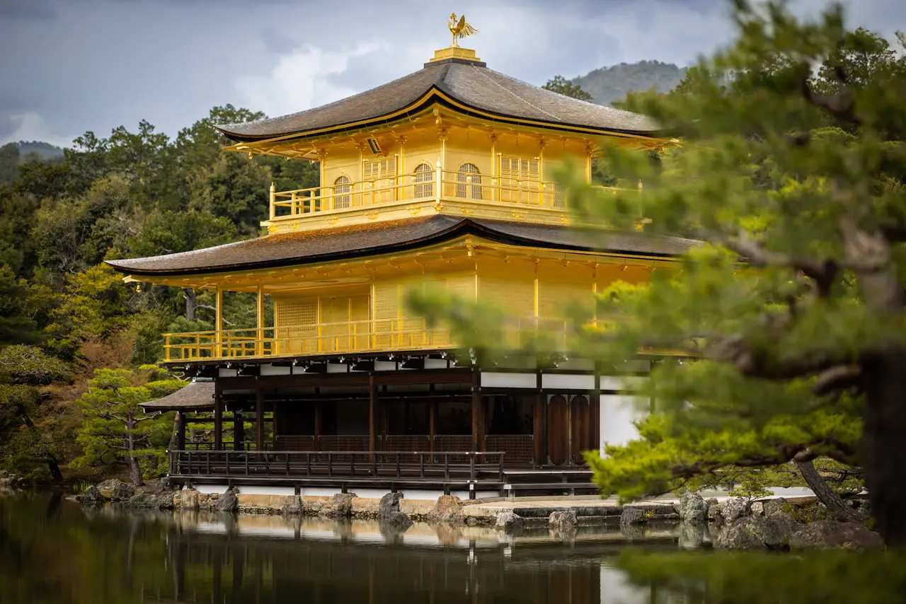 Voyage en Asie – Le pavillon d'or du temple zen Kinkaku-ji brillant au bord de l'eau et entouré de végétation à Kyoto au Japon.