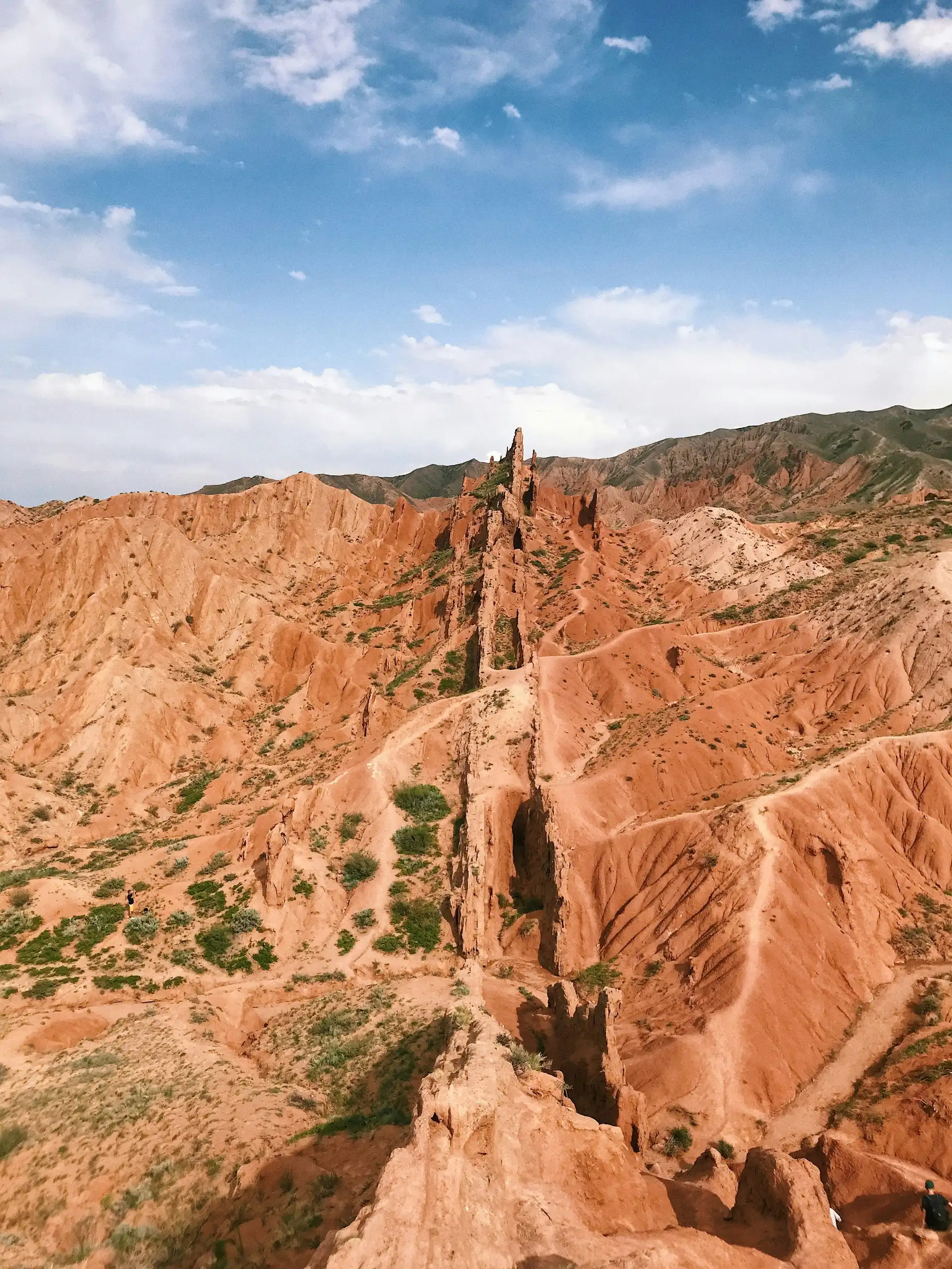 formations rocheuses de couleur rouge et ocre du canyon de skazka s elevant sous un ciel bleu au kirghizistan