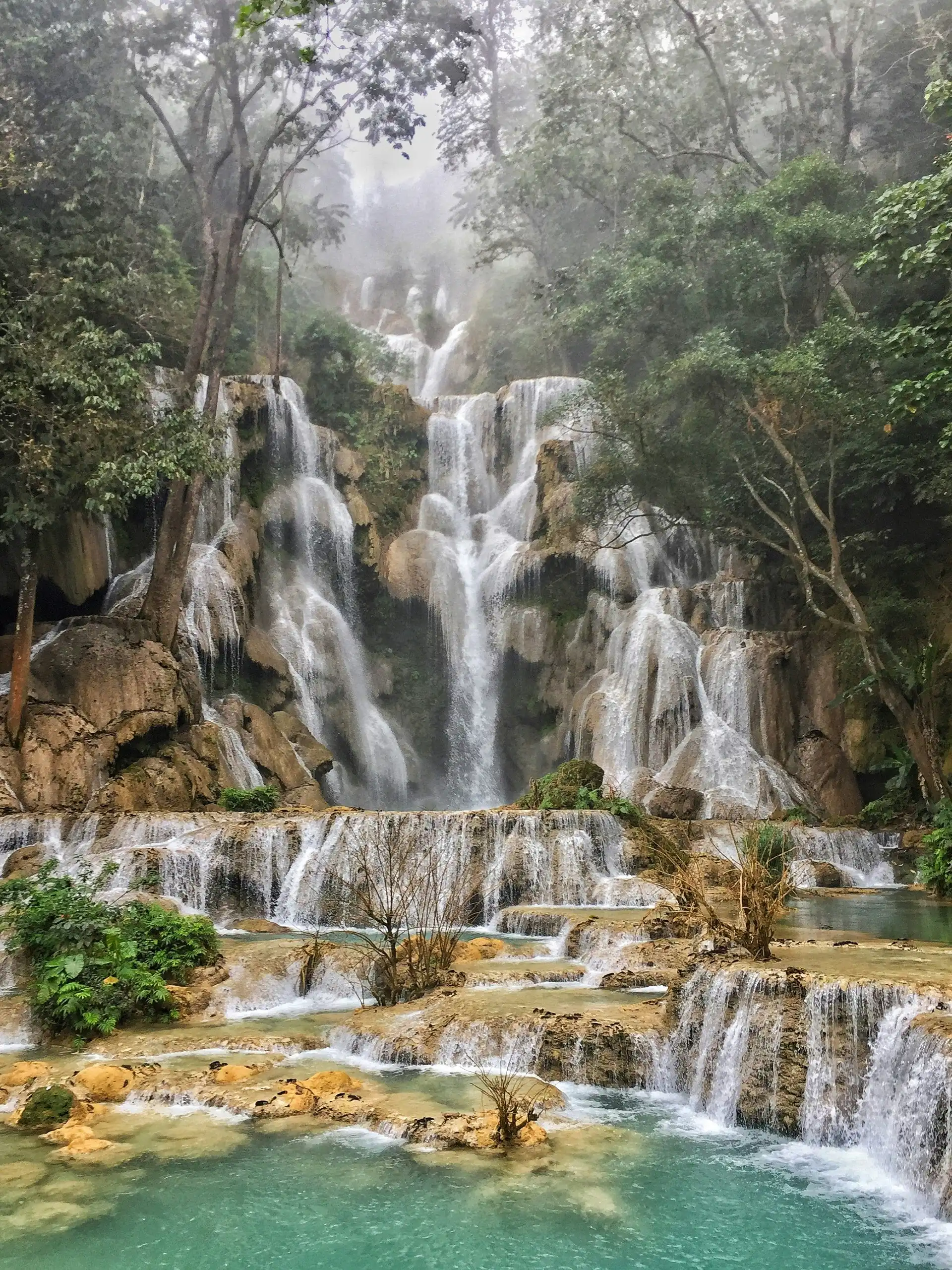 magnifique cascade a plusieurs niveaux s ecoulant au milieu d une foret luxuriante dans un bassin d eau turquoise au laos