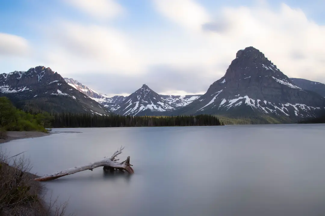 Un lac entouré de montagnes enneigées dans le parc national de Glacier, dans le Montana.