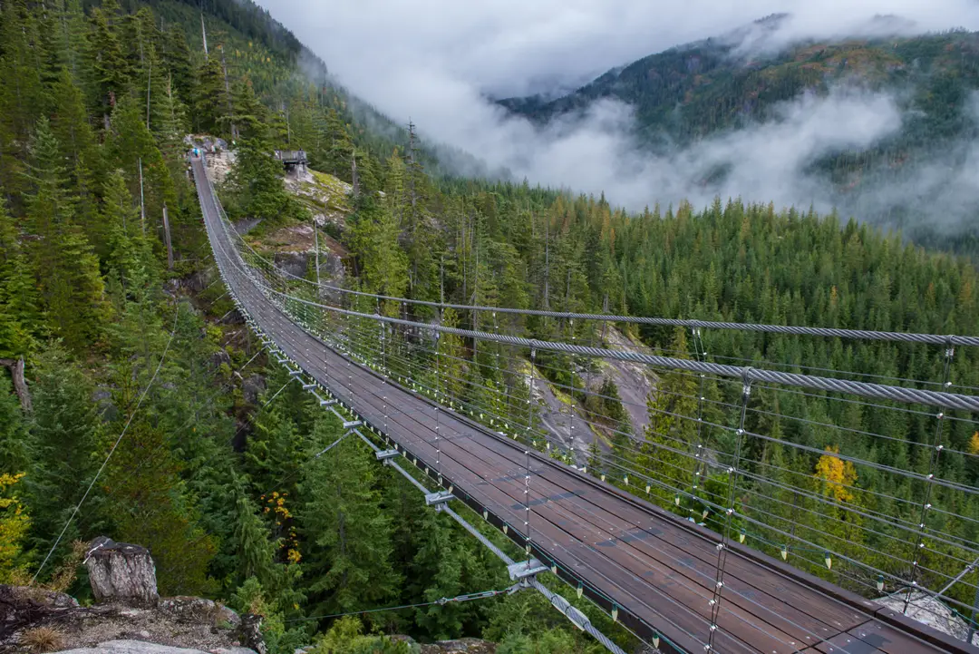 Pont suspendu Sky Pilot au milieu de la forêt et des montagnes brumeuses près de Squamish, en Colombie-Britannique.