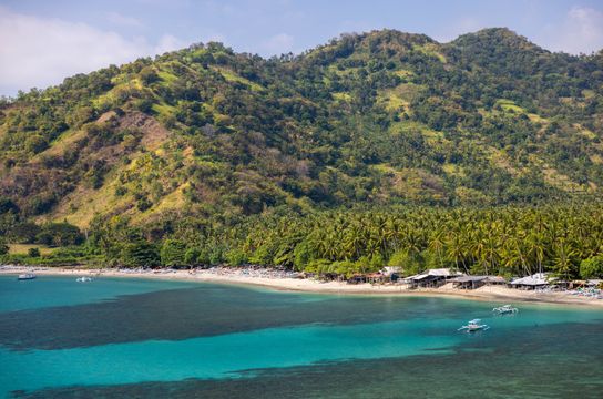 Plage de Senggigi : eaux turquoise, sable doré et végétation luxuriante.