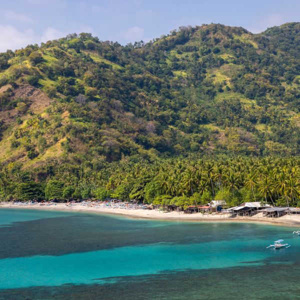 Plage de Senggigi : eaux turquoise, sable doré et végétation luxuriante.