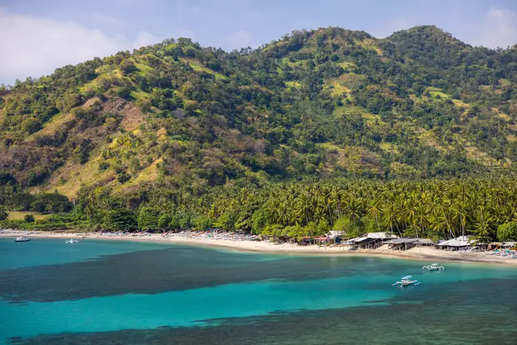 Plage de Senggigi : eaux turquoise, sable doré et végétation luxuriante.