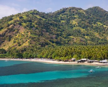 Plage de Senggigi : eaux turquoise, sable doré et végétation luxuriante.