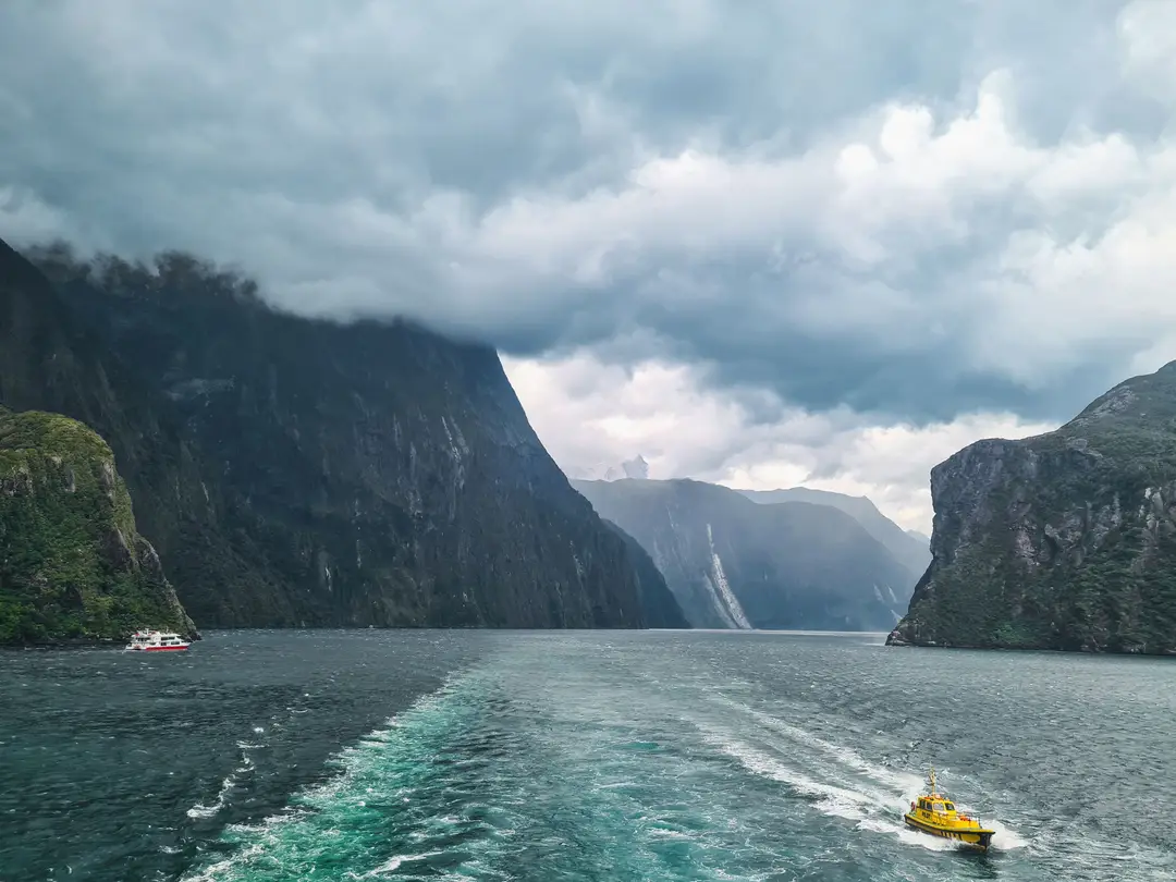 Milford Sound avec des bateaux naviguant à travers un magnifique paysage de fjord en Nouvelle-Zélande