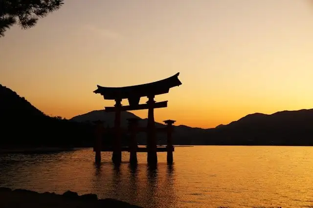Voyage en Asie — Silhouette emblématique du Torii de Miyajima au Japon, un moment d'émotion et de spiritualité au coucher du soleil — Shanti Travel