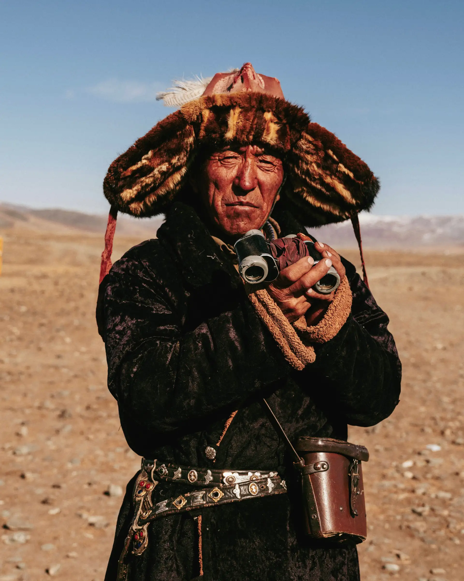 portrait d un homme nomade mongol portant une coiffe traditionnelle en fourrure et un manteau del chaud dans la steppe