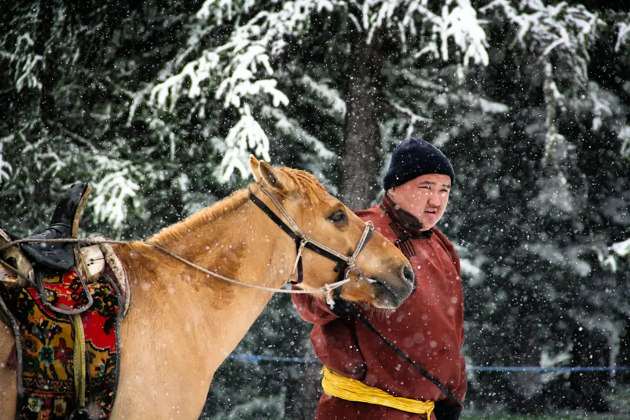 Un homme et son cheval en Mongolie en hiver