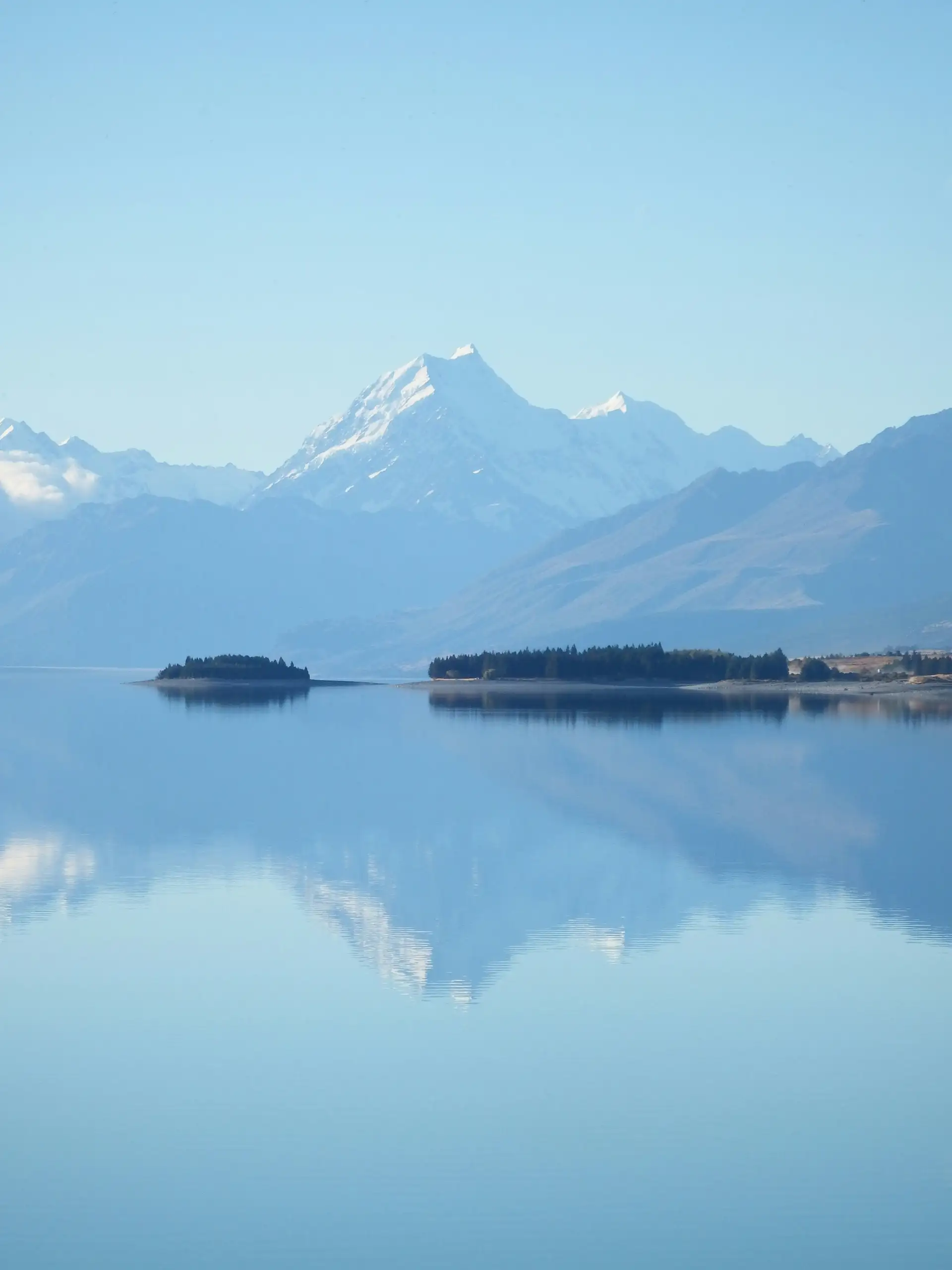 Reflet parfait des sommets enneigés du Mont Cook dans les eaux bleu azur du lac Pukaki en Nouvelle-Zélande.