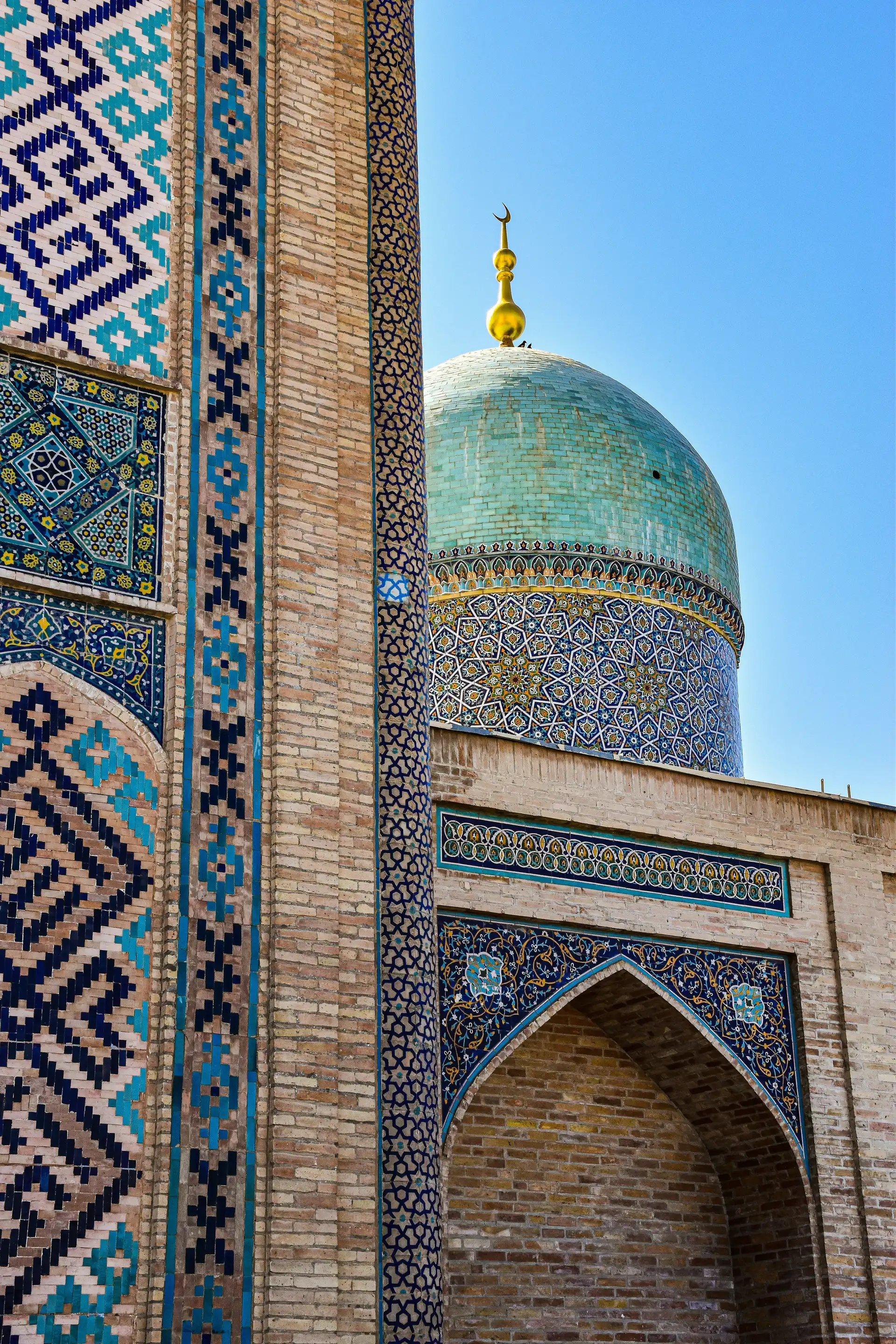 plan serre sur le dome turquoise et les murs de faience bleues aux motifs geometriques de la medersa miri arab a boukhara en ouzbekistan