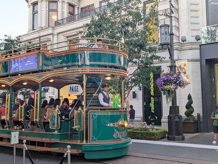 Tramway vintage vert à impériale circulant dans les allées commerçantes de The Grove à Los Angeles