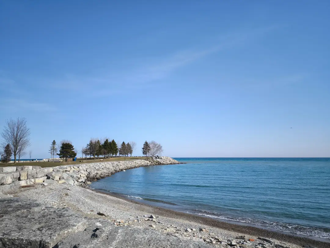 Paysage paisible du lac Ontario, avec un ciel bleu et plage rocheuse à Toronto, au Canada