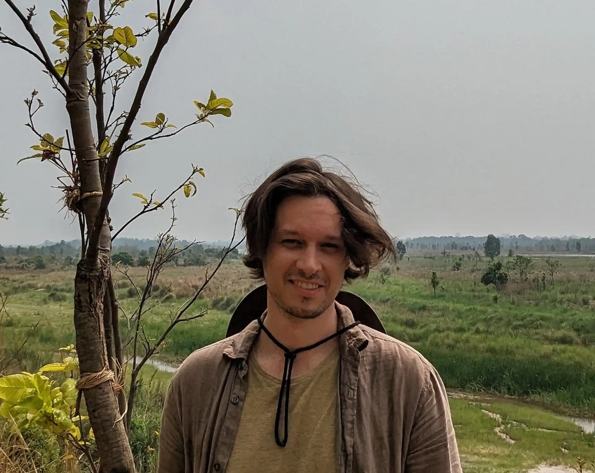 Portrait de Quentin Riffaud, responsable de la création et de la production chez Shanti Travel, souriant en extérieur au cœur d'un paysage naturel.