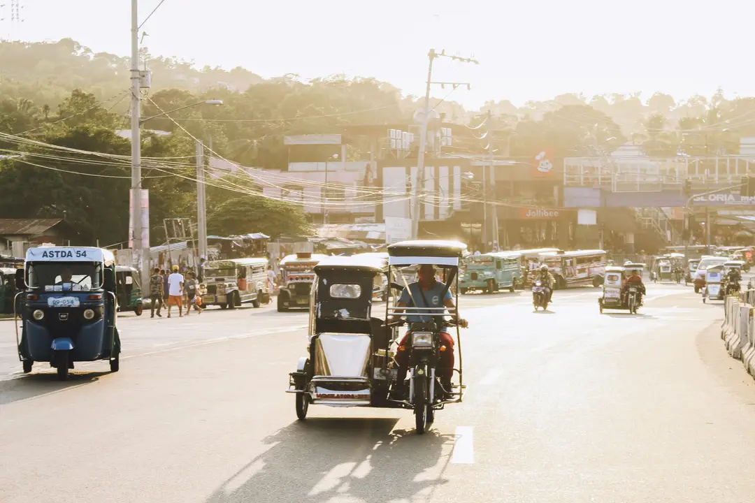Scène de rue ensoleillée avec des tricycles aux Philippines.