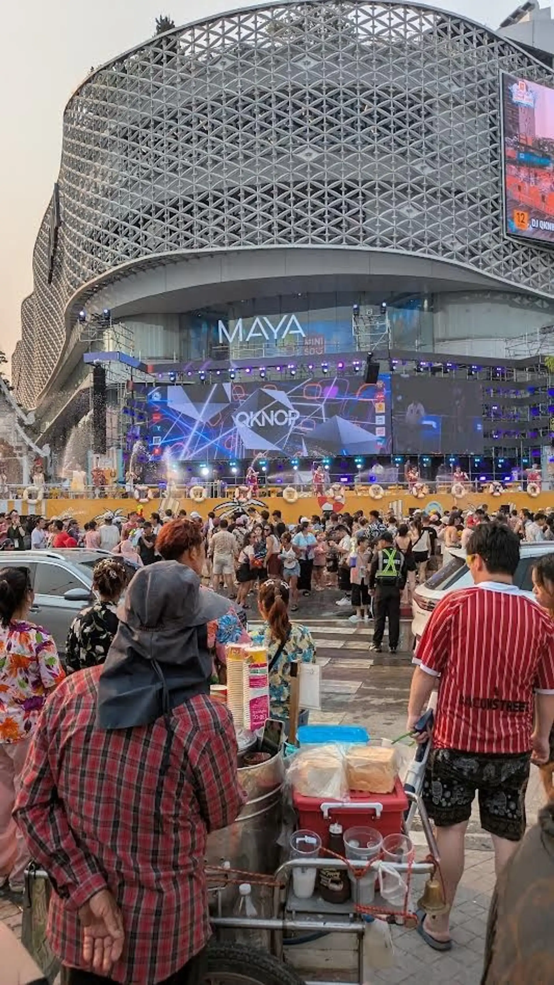 foule festive rassemblee dans la rue devant un grand centre urbain moderne celebrant le nouvel an bouddhique sous des jets d eau