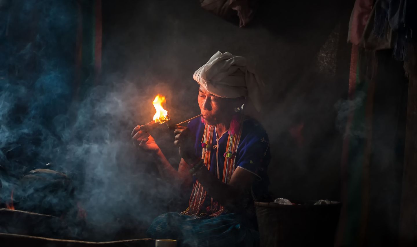 Travel in Asia - A woman of the Karen hill tribe in Thailand smoking a traditional tobacco pipe