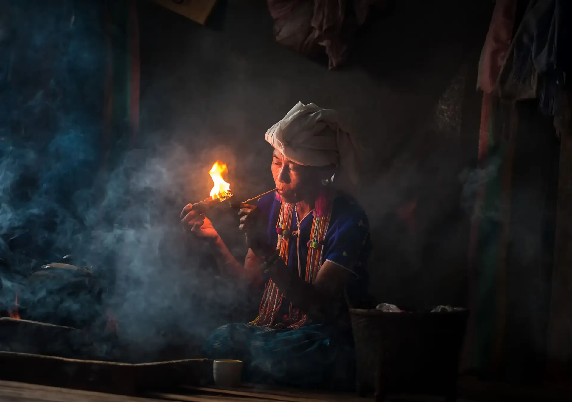 Travel in Asia - A woman of the Karen hill tribe in Thailand smoking a traditional tobacco pipe