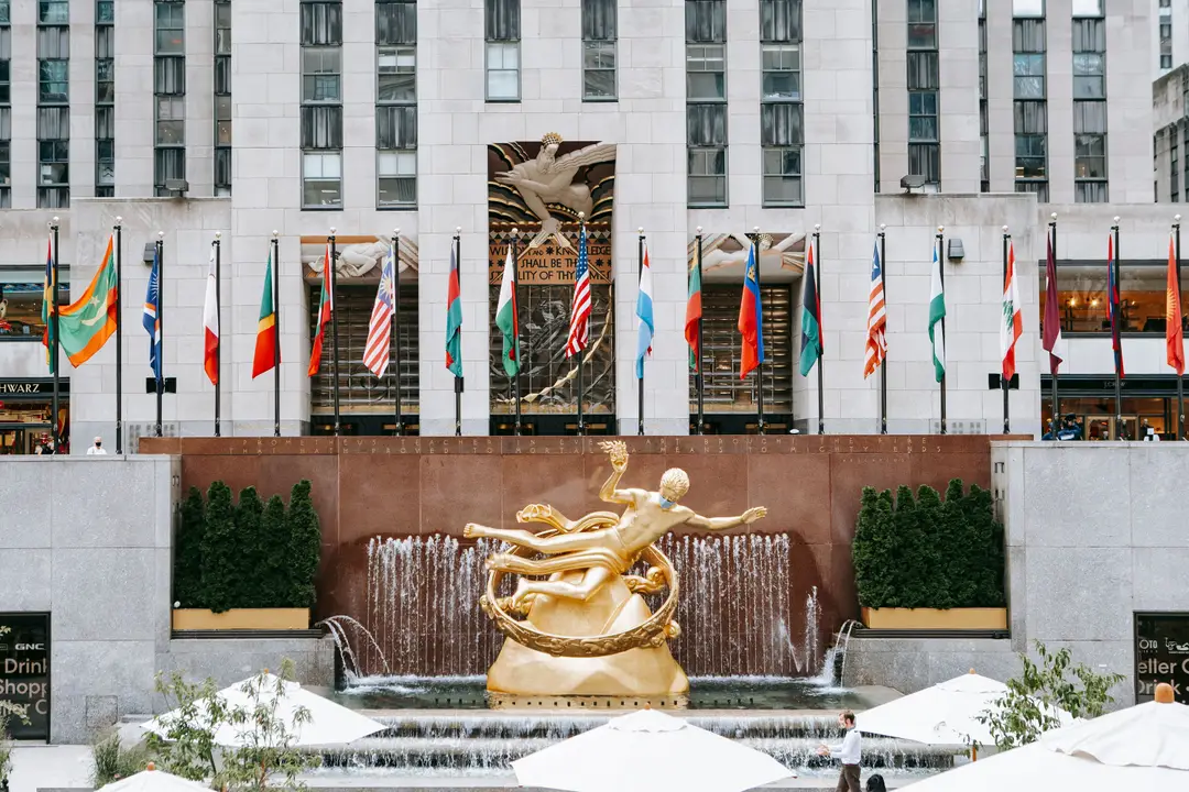 Statue emblématique de Prométhée avec des drapeaux et une fontaine au Rockefeller Center, New York