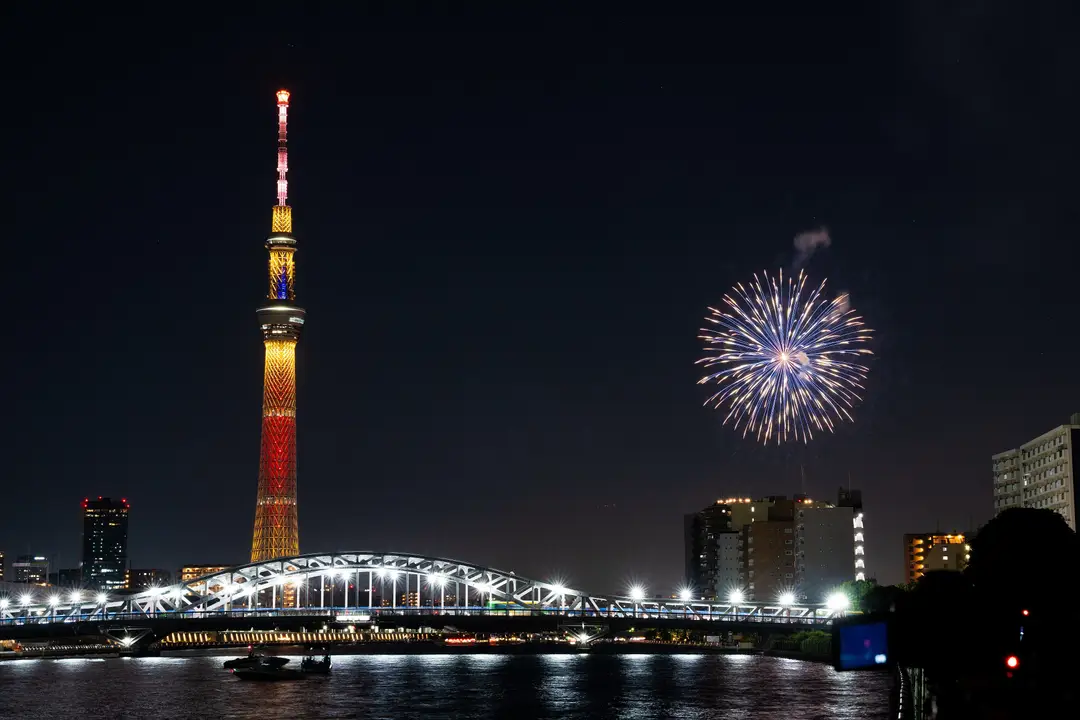 Voyage au Japon – Grandiose feu d'artifice éclatant dans le ciel nocturne de Tokyo au-dessus de la rivière Sumida avec la tour Tokyo Skytree illuminée.