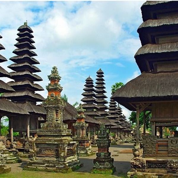Voyage en Asie — Complexe de temples hindous Pura Taman Ayun à Bali : meru étagés, bases sculptées et ciel bleu ensoleillé.