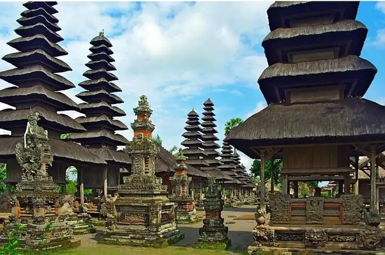 Voyage en Asie — Complexe de temples hindous Pura Taman Ayun à Bali : meru étagés, bases sculptées et ciel bleu ensoleillé.