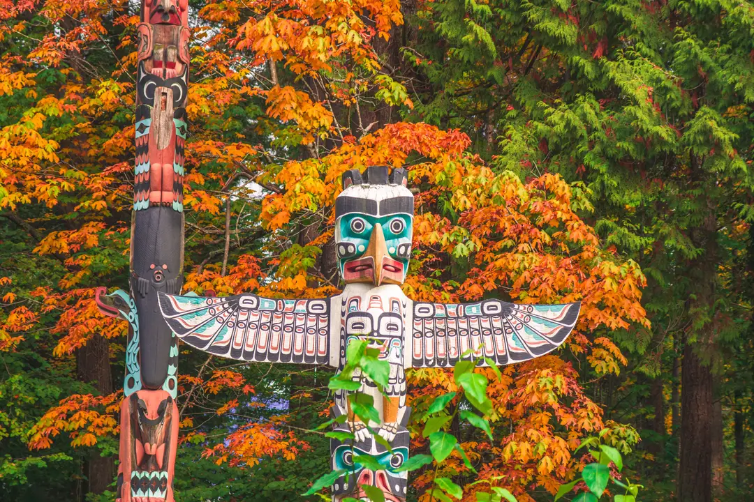 Poteau sculpté au milieu du feuillage d’automne à Vancouver, au Canada.