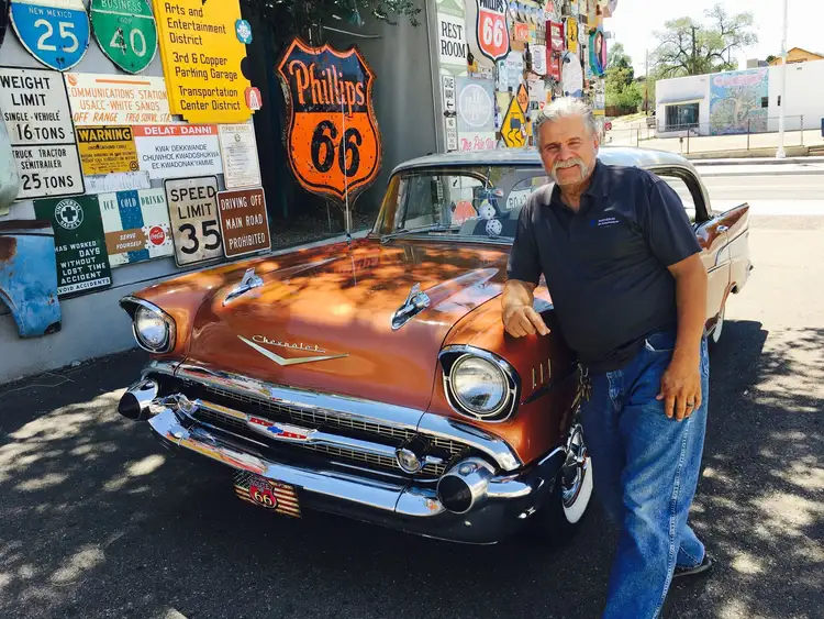 Homme américain posant devant sa voiture au bord de la route 66